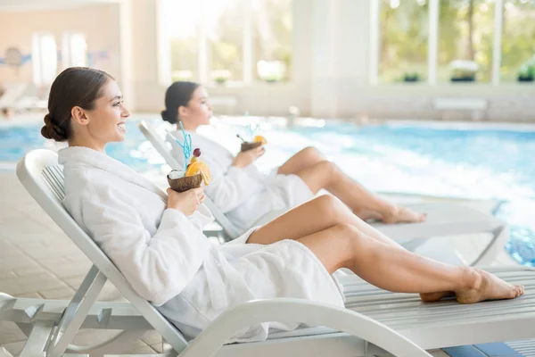 Serene Meisjes Witte Badjassen Liggend Ligstoelen Bij Zwembad Genieten Van — Stockfoto