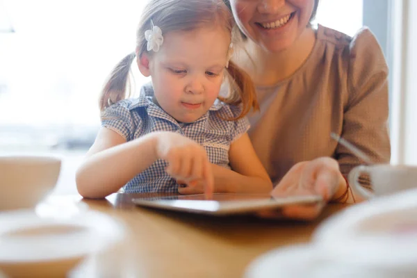 Chica Curiosa Navegando Red Mientras Madre Sostiene Touchpad — Foto de Stock