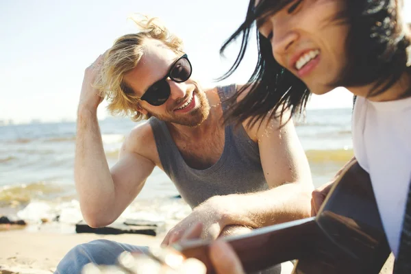 ビーチで夏休みを楽しんでいるギターを持つ幸せな男 — ストック写真