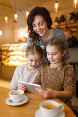 Kadın ve küçük kızlar kafede boş zaman zevk touchpad ile