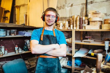 Carpenting studio çalışma gülümseyen genç adam portresi, silah ile kamera ayakta bakarak geçti