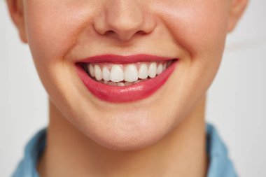 Beyaz arka plan karşı büyüleyici dişlek gülümseme ile kadın yüzü yakın çekim çekim
