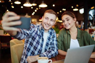 İki yakın arkadaşlarım ile geniş gülümsüyor güzel kahvehane ve alma resim kendilerini, bel, dikey dışarı asılı