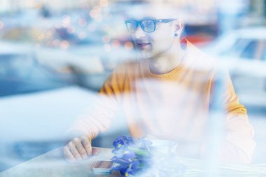 Buket çiçek, cam pencere atış ile kafede Tarih için bekleyen genç adam