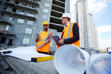 İki mühendis Blueprint bitmemiş yapısı ile arka plan üzerinde tartışıyor