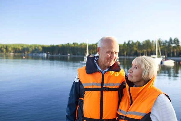 成年夫妇穿着救生衣 在湖边消磨时光 — 图库照片