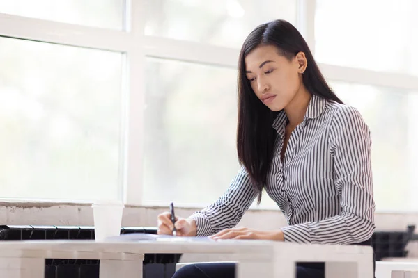 Konzentrierte Asiatische Geschäftsfrau Sitzt Geräumigen Büro Und Macht Sich Notizen — Stockfoto