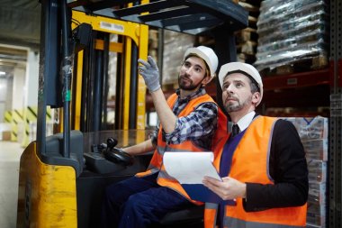 Onun asıl'konuşurken forklift çalışan bir warehous de işaret eden raflar