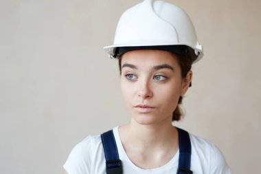 Kadın inşaat işçisi işçisi ayakta beyaz duvar arka plan karşı portresi