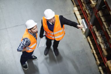 Yukarı dönük mal uzun raflarda sayma stocktaking yapıyor iki ambarı işçilerin görünümünün üst