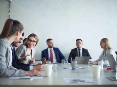 Grup gülümseyen ve tablo konferans salonunda toplantı sohbet neşeli iş adamları