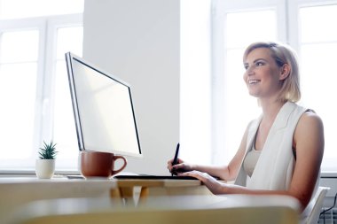 Mutlu genç yaratıcı tasarımcı bilgisayar monitörü önünde siting ve office görüntü rötuş