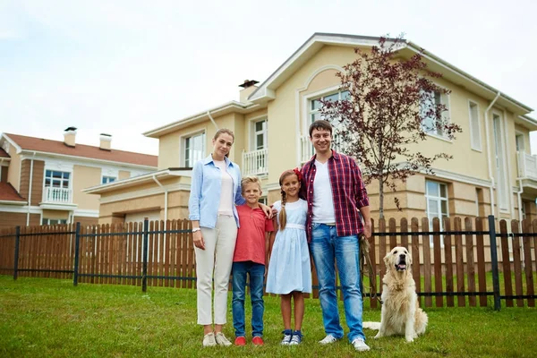 Lyckliga Föräldrar Barn Och Deras Hund Grönt Gräs Nya Hus — Stockfoto