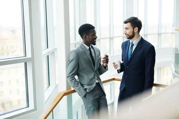 Retrato Jovem Empresário Barbudo Conversando Com Colega Afro Americano Segurando — Fotografia de Stock