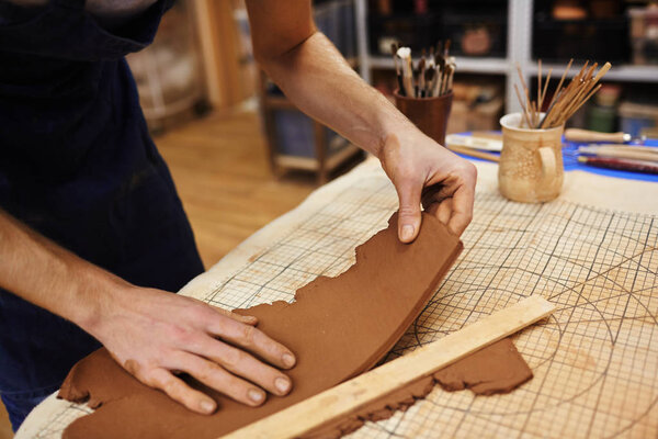 Hands of pitcher separating piece of clay