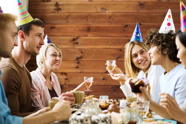 お茶の中に誕生日のテーブルで話を持つ若い男性と女性のグループ — ストック写真