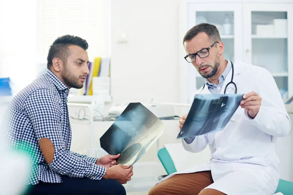 Seriöser Radiologe Zeigt Dem Patienten Röntgenbilder Von Gelenken Und Berät — Stockfoto