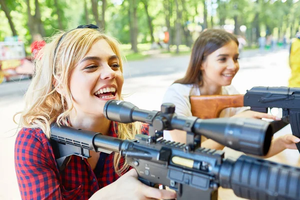 Portrait Two Beautiful Women Aiming Big Rifle Outdoor Game Tent — Stock Photo, Image
