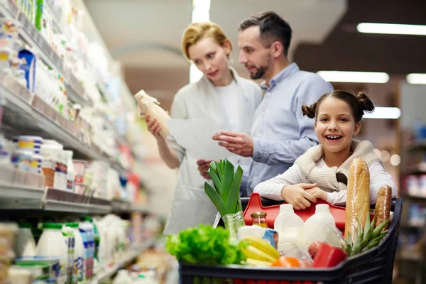 Chica Mirando Cámara Supermercado Fondo Sus Padres Elección Productos Lácteos — Foto de Stock