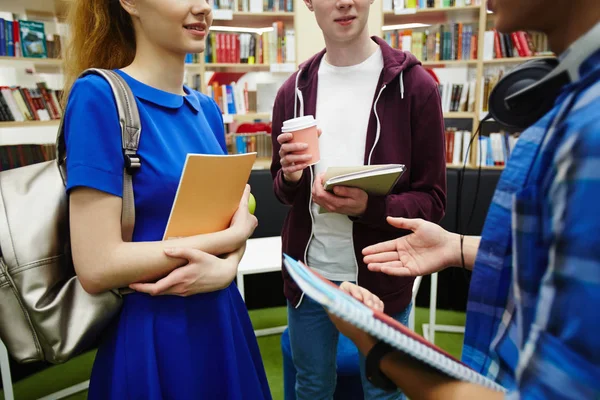 Zbliżenie Strzał Nastoletnich Uczniów Trzymania Książek Omawiając Projekt Studia Bibliotece — Zdjęcie stockowe