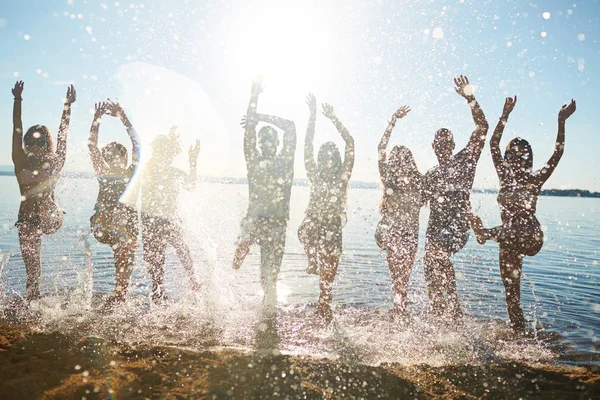 Speelse Tieners Verhogen Handen Terwijl Het Opspattend Water Door Zand — Stockfoto