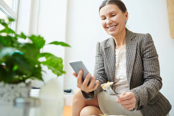 Fröhliche Seniorin Hält Gabel Der Hand Während Sie Mit Ihrem — Stockfoto