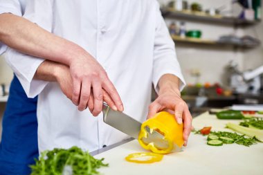 Stajyer ve chef malzemeler salata için dilimleme