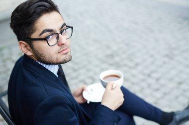 Havalı adam açık havada çay içiyor takım elbiseli