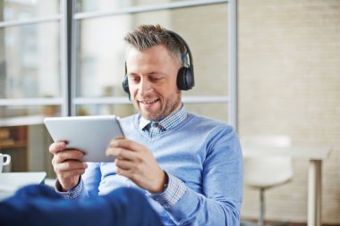 Gülümseyen orta yaşlı işadamı Kulaklığımda webinar zevk ne zaman o ofiste çalışan