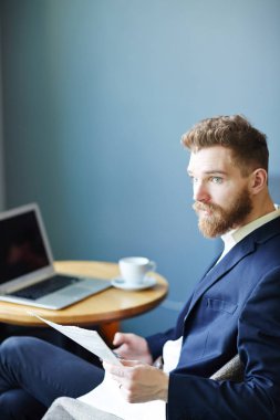 Kafede vakit kağıt ile meşgul genç tüccar