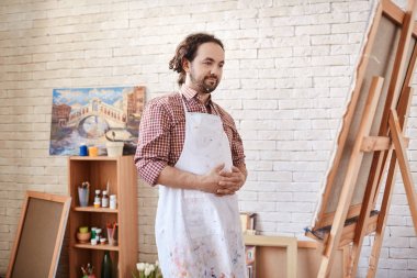 Onun bitmiş resim atölye bakarak ve gülümseyen gurur sanatçı portresi