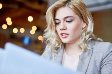 Baş ve omuz portre çekici sarı saçlı beyaz yakalı işçi eğitim Belgeler Ofis Masası, arka plan bulanık otururken