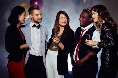 Gece kulübünde eğleniyor neşeli arkadaş grubu: animatedly birbirleriyle sohbet ve şampanya, kalın içki içiyorlar arka plan üzerinde