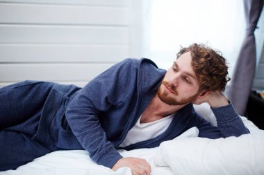 Üzgün adam uykusuz gece boyunca yatakta yatan