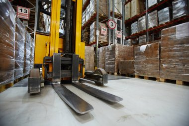 Depolama rafları arasında koridor forklifti