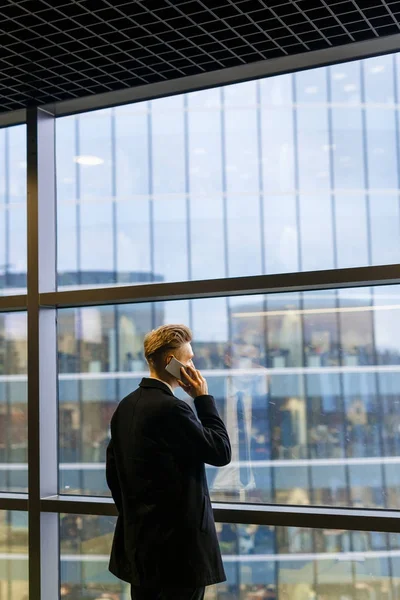 Αγνώριστος Επιχειρηματίας Μοντέρνα Κούρεμα Κοιτάζοντας Από Παράθυρο Του Γραφείου Συζητώντας — Φωτογραφία Αρχείου
