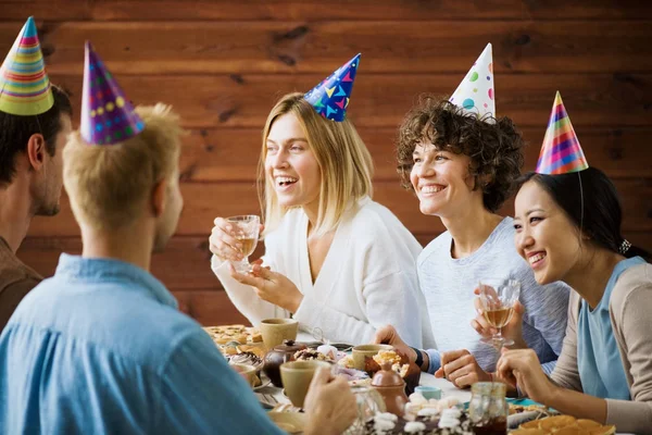 Vrolijke Vrienden Verjaardag Caps Door Feestelijke Tafel Zitten Met Praten — Stockfoto