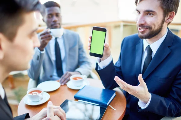 现代年轻商人的肖像热情地向同事展示手机应用程序 在咖啡馆的会议上显示他们的智能手机 — 图库照片