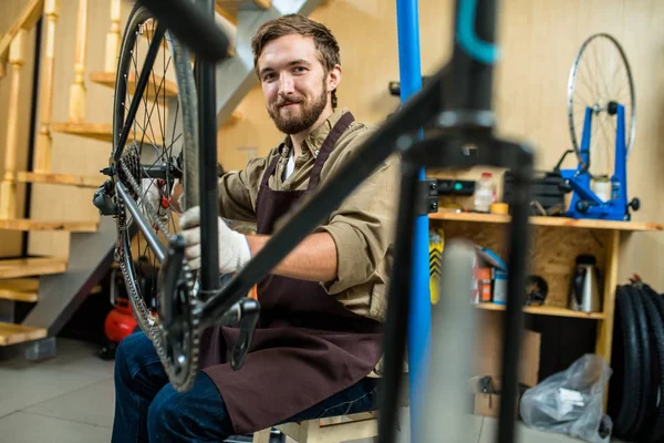 Maestro Riparazione Successo Con Bicicletta Guardando Fotocamera Durante Lavoro — Foto Stock