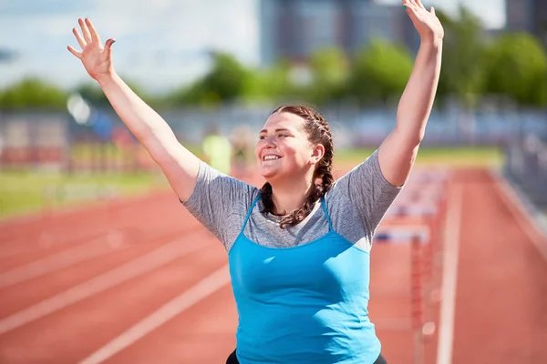 Erfolgreiche Übergroße Frau Hebt Nach Zieldurchlauf Die Hände — Stockfoto