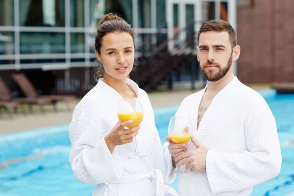 飲み物は スイミング プールで 夏のリゾート地で休暇を過ごすと穏やかな若いカップル — ストック写真