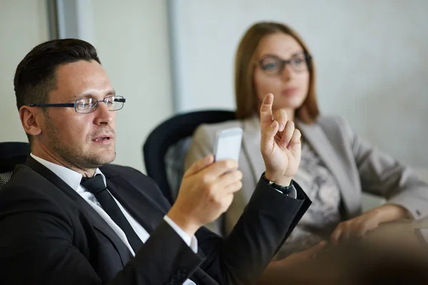 Arbeiter Mittleren Alters Checkt Mails Auf Dem Smartphone Während Projektdiskussionen — Stockfoto