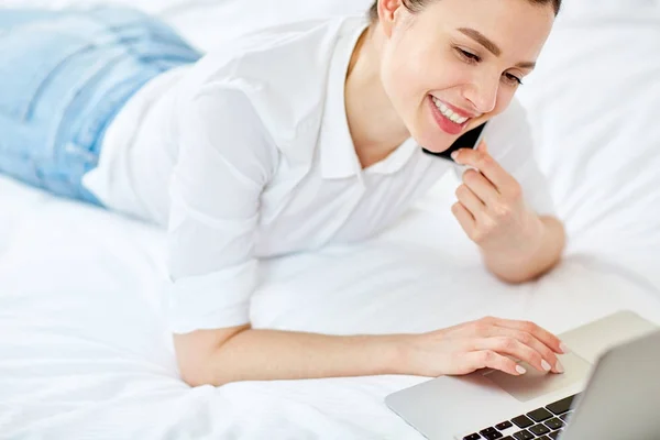 快乐的女孩说在智能手机和网上浏览 而躺在床上 — 图库照片