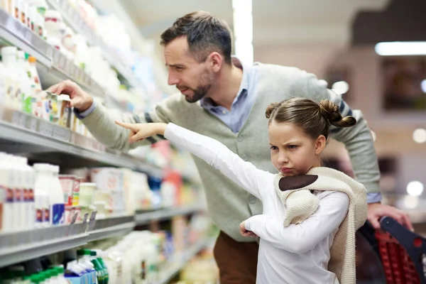 スーパー マーケットで彼女のおいしいヨーグルトを購入する彼女の父を求めて気まぐれな娘 — ストック写真