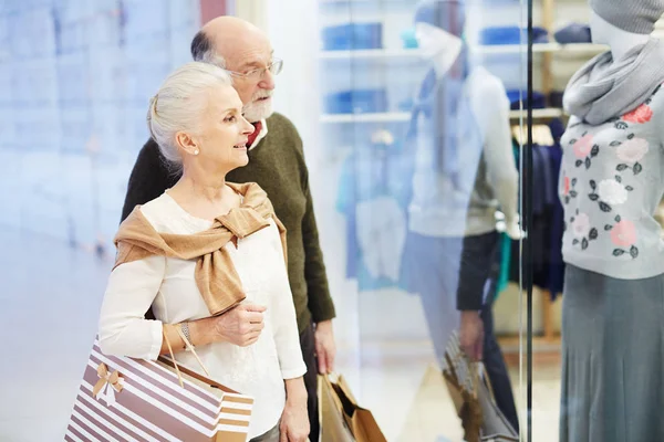 Senioren Paar Mit Papiertüten Betrachtet Kleidung Schaufenster — Stockfoto
