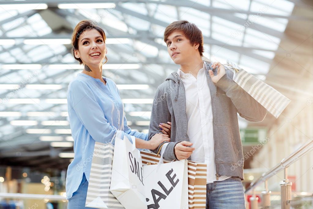 Young affectionate couple visiting traditional xmas sale in large mall