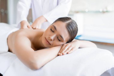 Sakin kadın spa salonda yalan ve onu geri Masaj