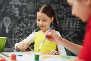 Portre sevimli gülümseyen küçük çocukların tahta karşı oturan sanat stüdyo sınıf resimleri boyama