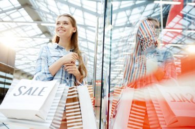 Genç müşteri Vitrini tarafından Black Friday satış sırasında ayakta çanta ile