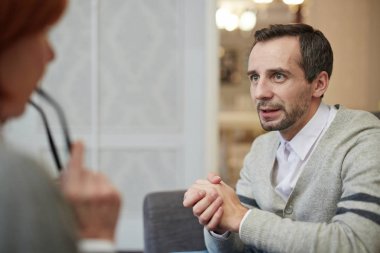 Endişeli adam onun hikayesi için psikolog söylüyor